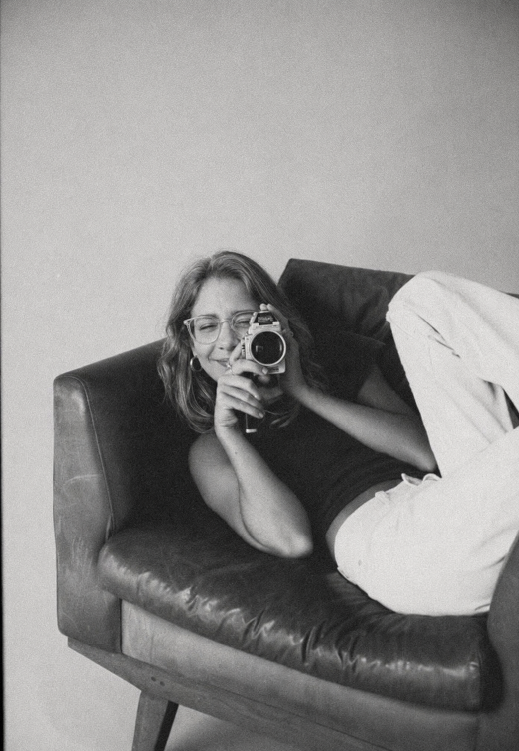 Rosie relaxing in a vintage leather armchair with her camera